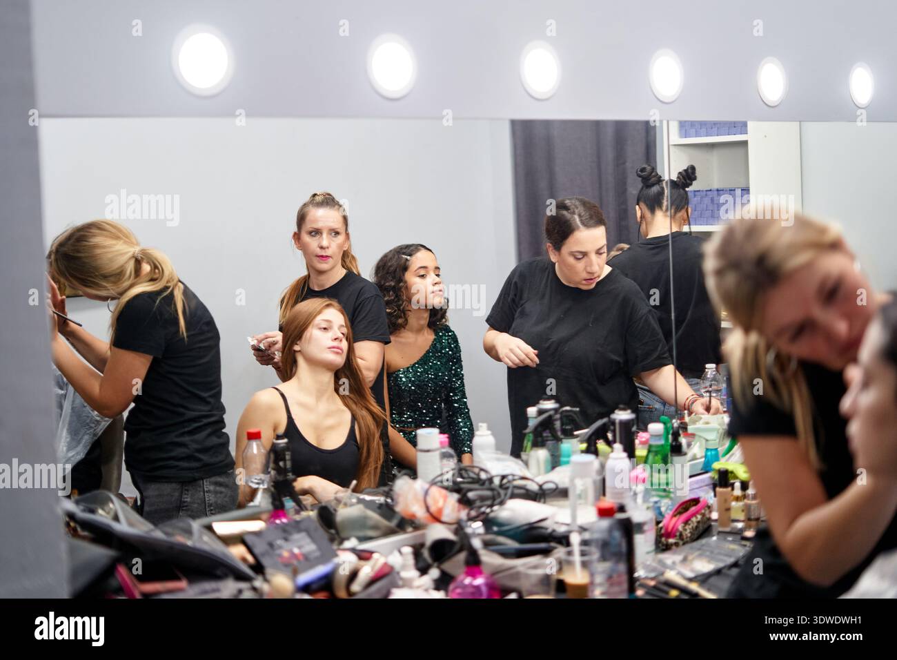 Makeup Studio Model A group of models and makeup artists work together in a well-lit studio ...