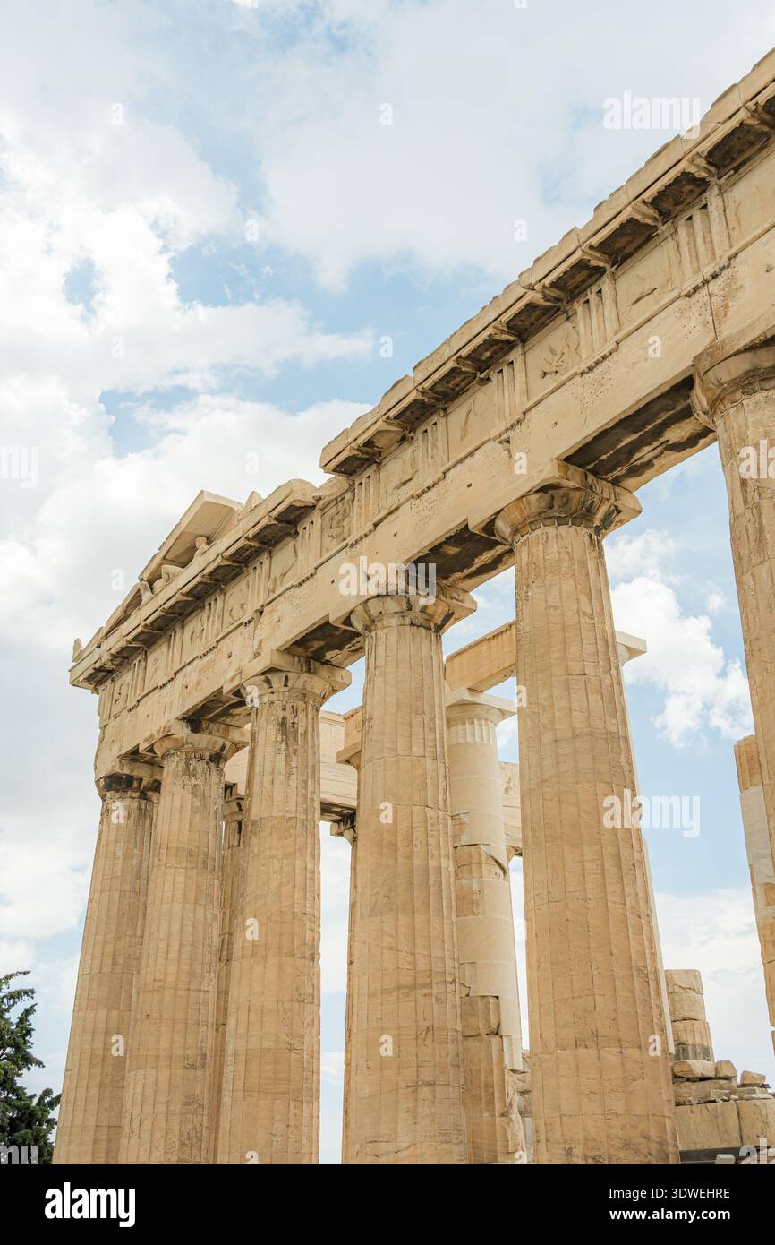 The majestic ancient Greek temple showcases the timeless beauty of Doric columns set against a backdrop of a clear blue sky, capturing the essence of Stock Photo