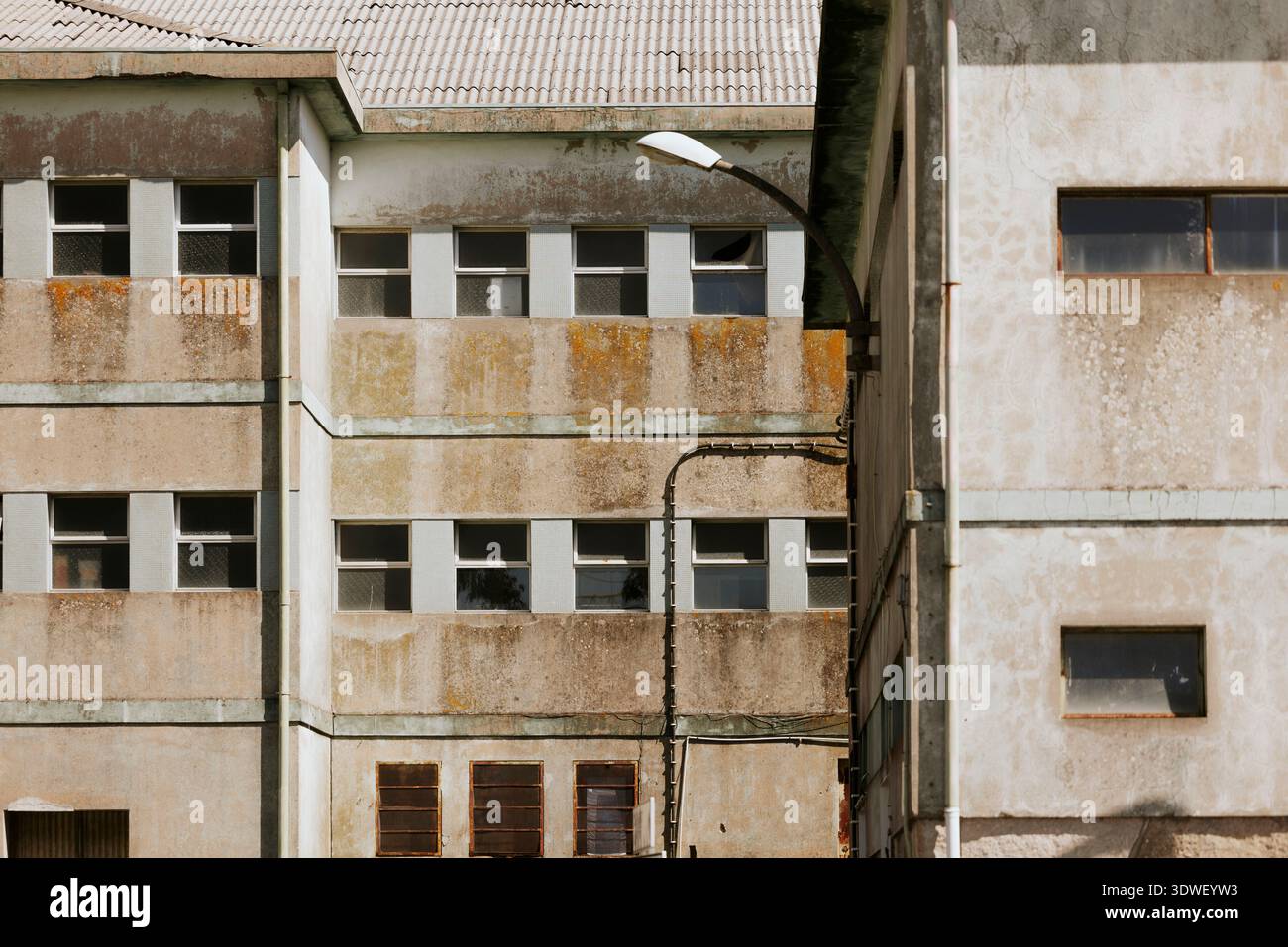 A weathered, industrial building facade featuring aging concrete and ...