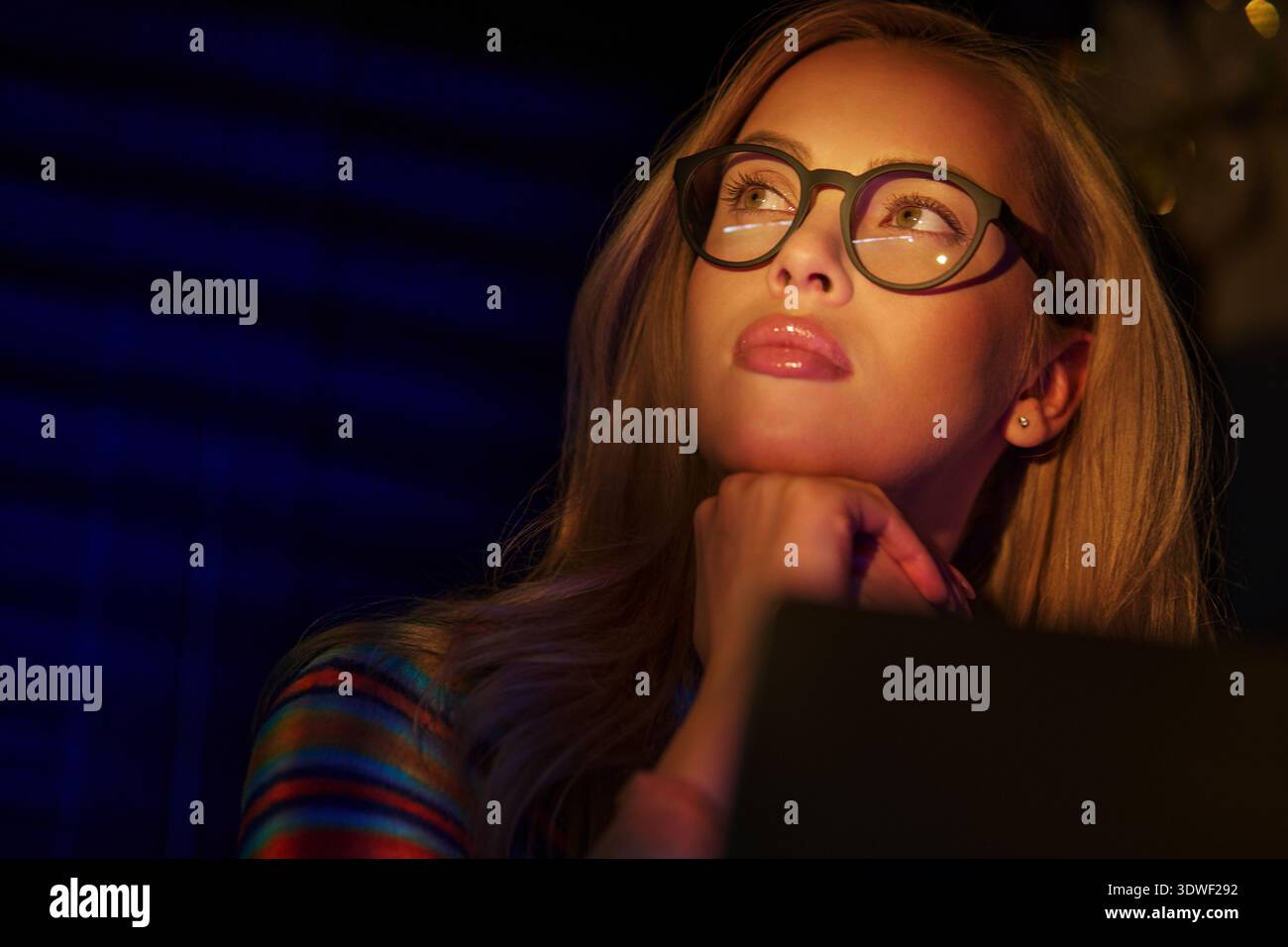 Blond woman using laptop and working late Stock Photo