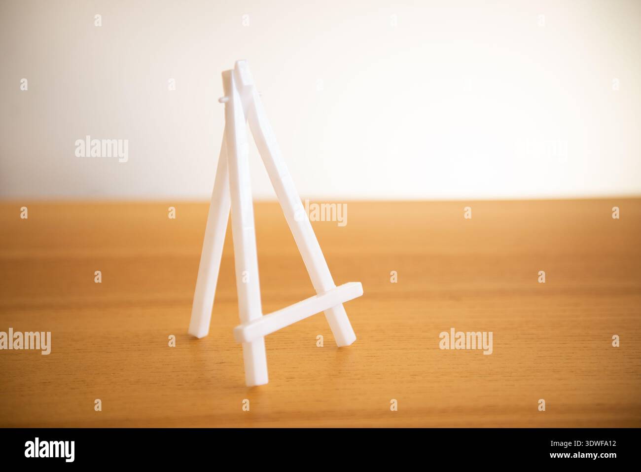 Small white easel mockup on a table background Stock Photo