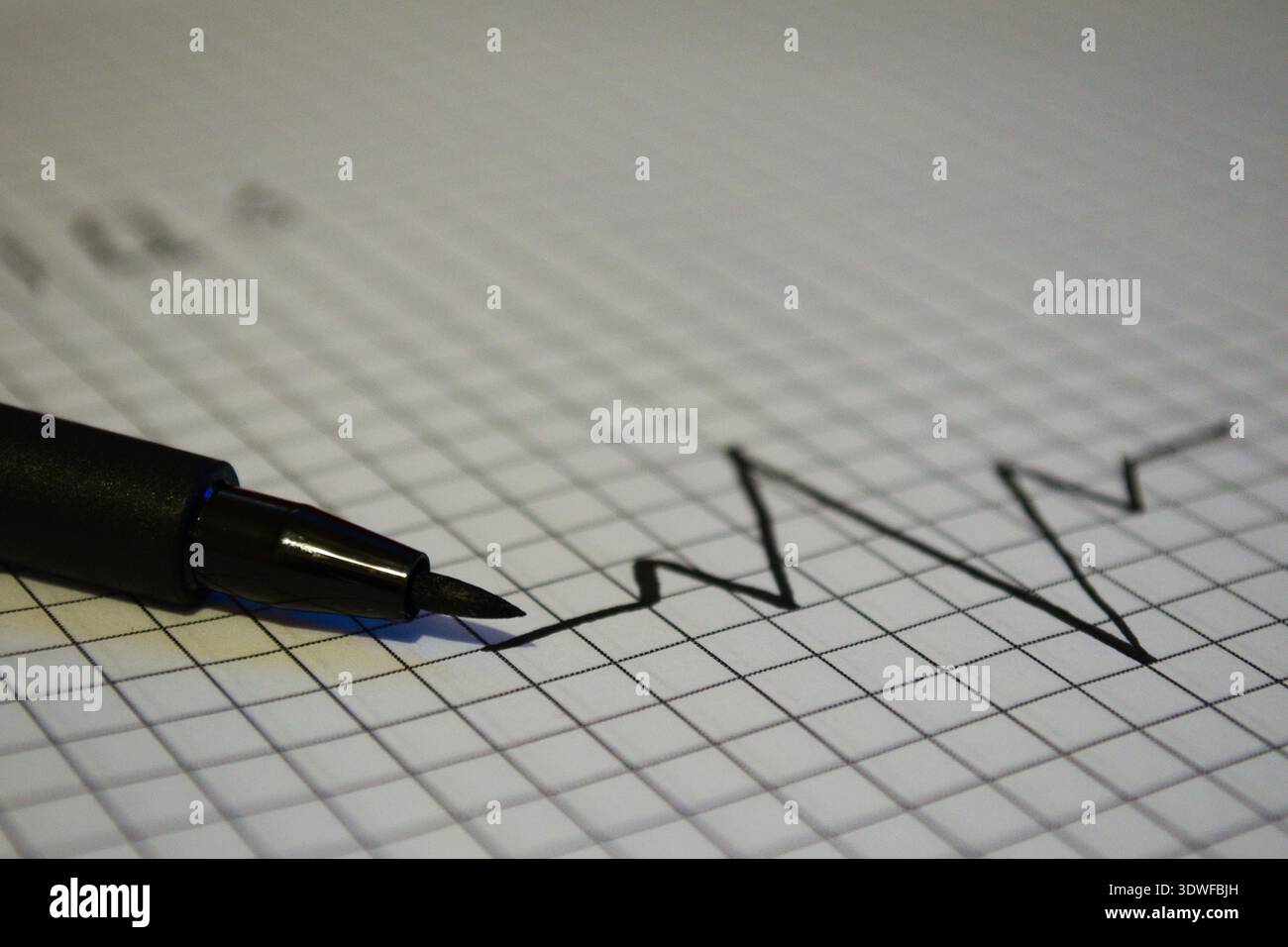 Black felt tip pen drawing a sharp growth chart or heartbeat line on ...