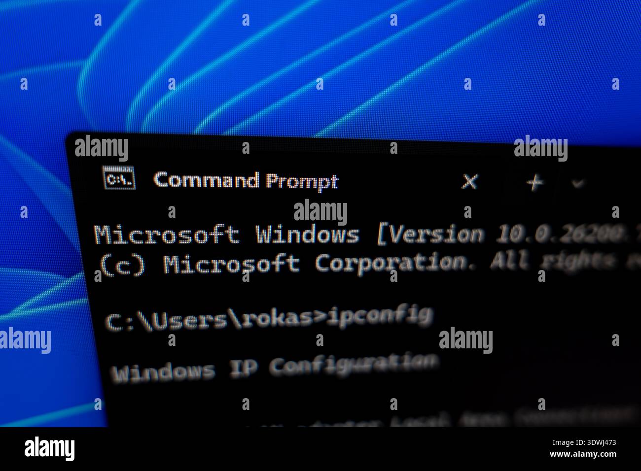 Close-up of Windows Command Prompt window on a computer screen showing ipconfig command, concept for network troubleshooting and system administration Stock Photo