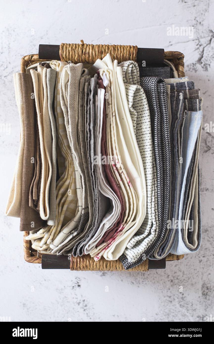 Kitchen textile. stack of fabrics in different colors and textures, close-up. Kitchen towels on white background. Many fabric kitchen napkins in a wic Stock Photo