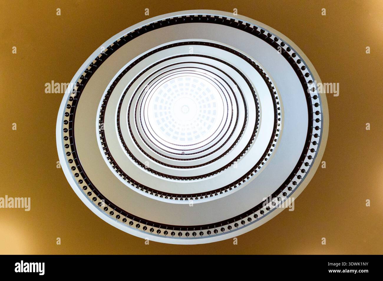 A stunning spiral staircase viewed from below, creating a mesmerizing geometric pattern. Stock Photo