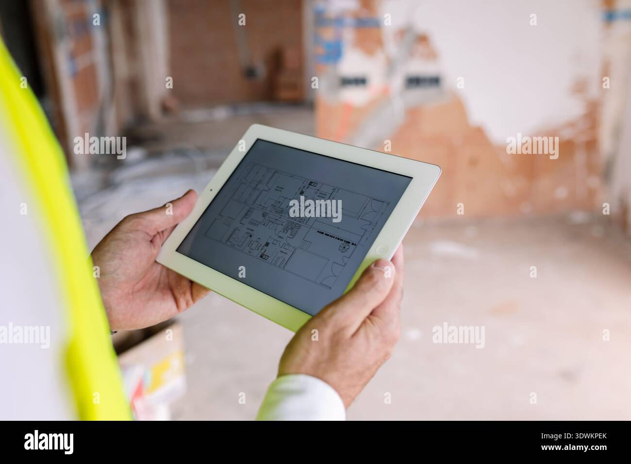 Engineer using tablet showing blueprint at construction site Stock Photo