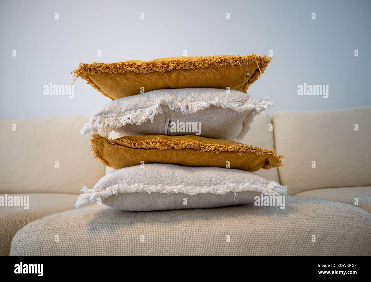 Stack of decorative pillows on sofa in cozy Scandinavian living room Stock Photo