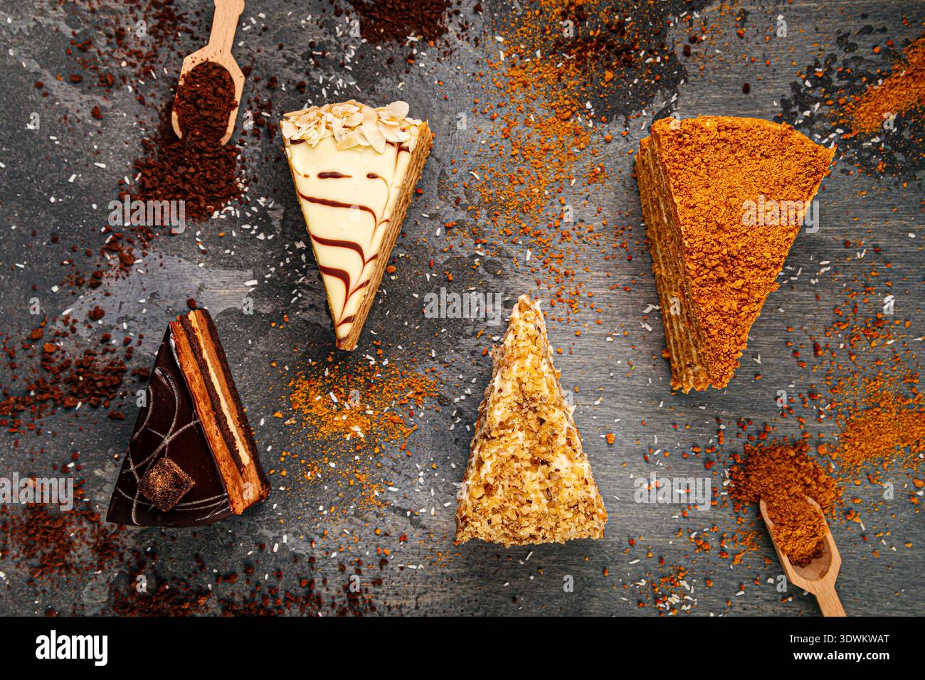 Assorted layered cake slices on dark table Stock Photo