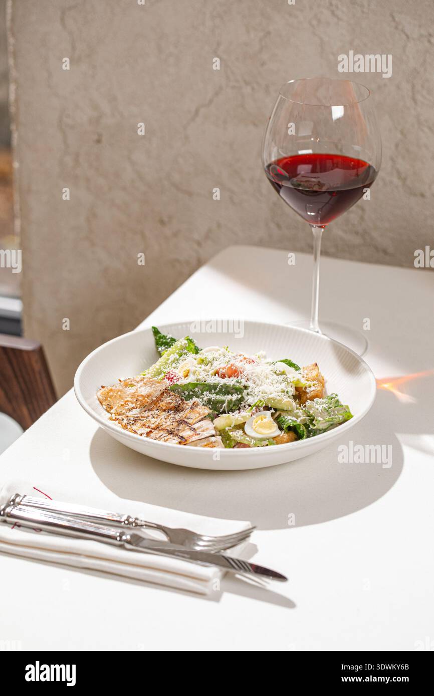Caesar salad with grilled chicken and wine Stock Photo