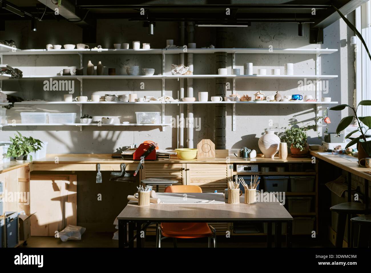 Empty Pottery Studio Workspace Displaying Sunlit Tools and Ceramic Creations Stock Photo