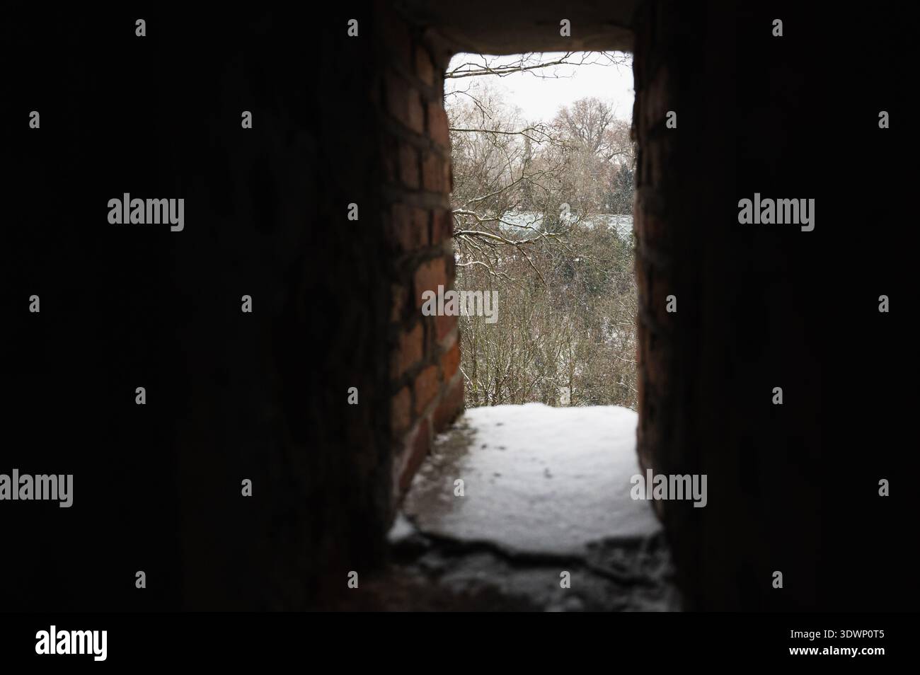 Winter scene through small window opening. Frosted landscape viewed from cozy window frame Stock Photo