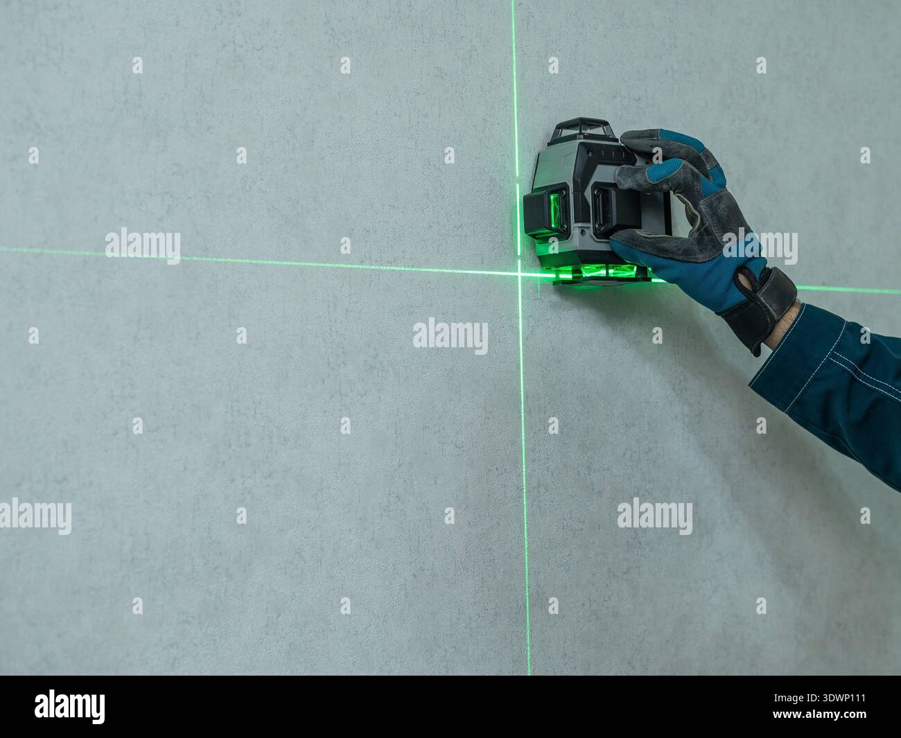 A man measures distance with a laser level. Stock Photo