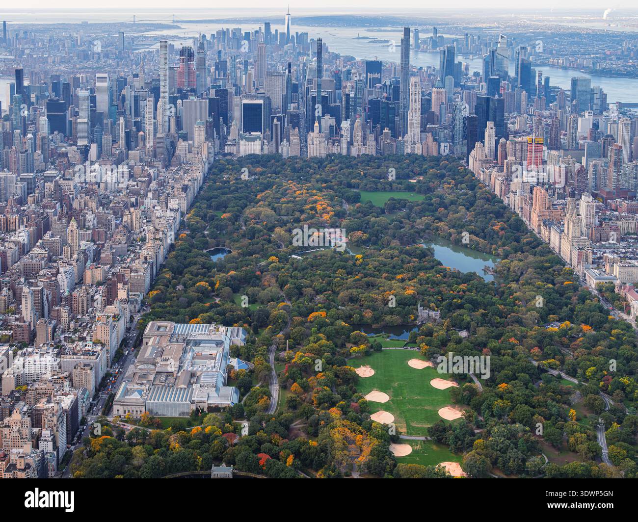 Aerial view of Central Park surrounded by the Manhattan skyline in New York City during autumn. The iconic urban park contrasts with dense Midtown sky Stock Photo