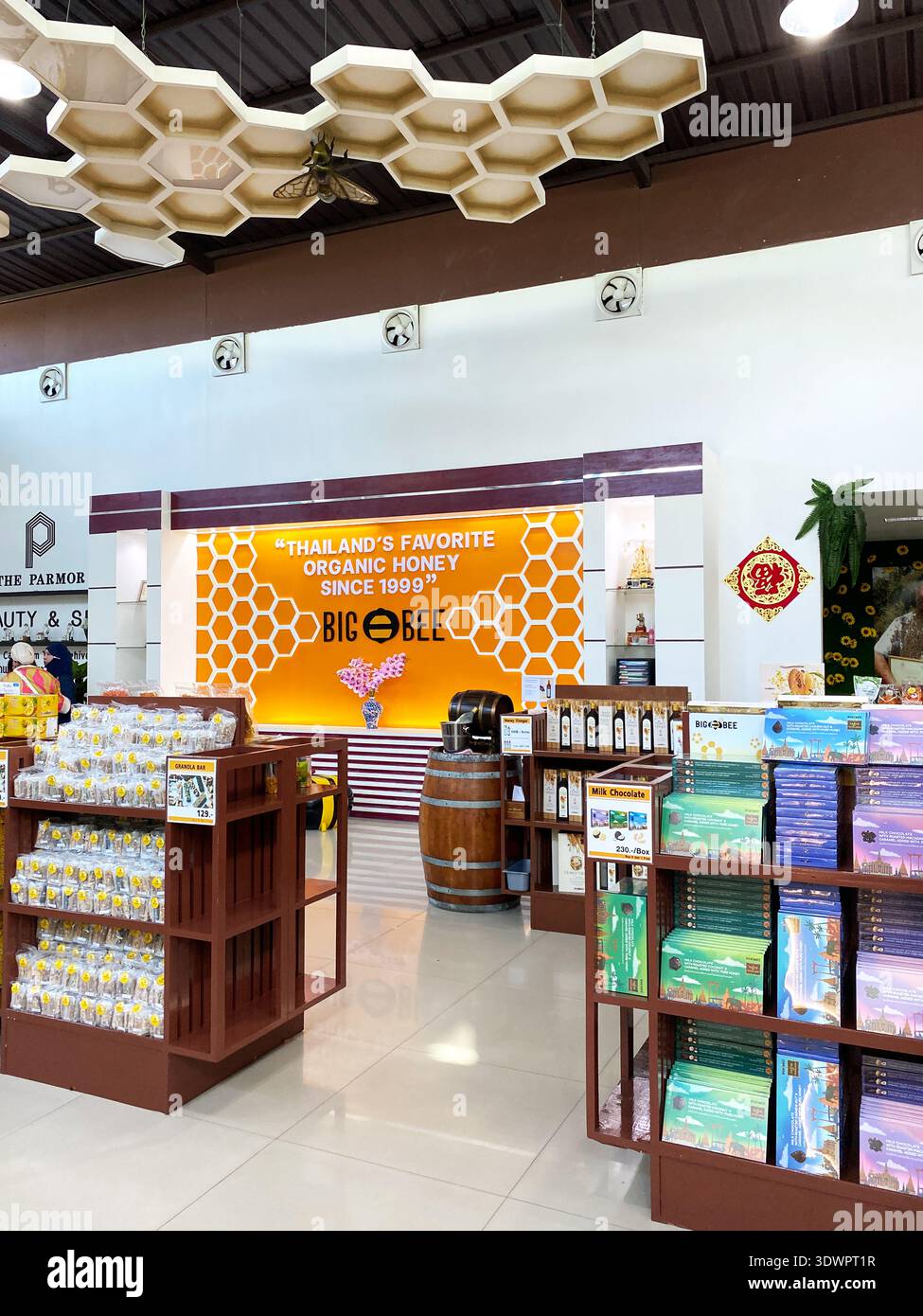 Phuket, Thailand - October 30, 2025: Interior view of a honey shop showcasing product shelves, a honey barrel, and a wall sign stating "Thailand's Fav Stock Photo