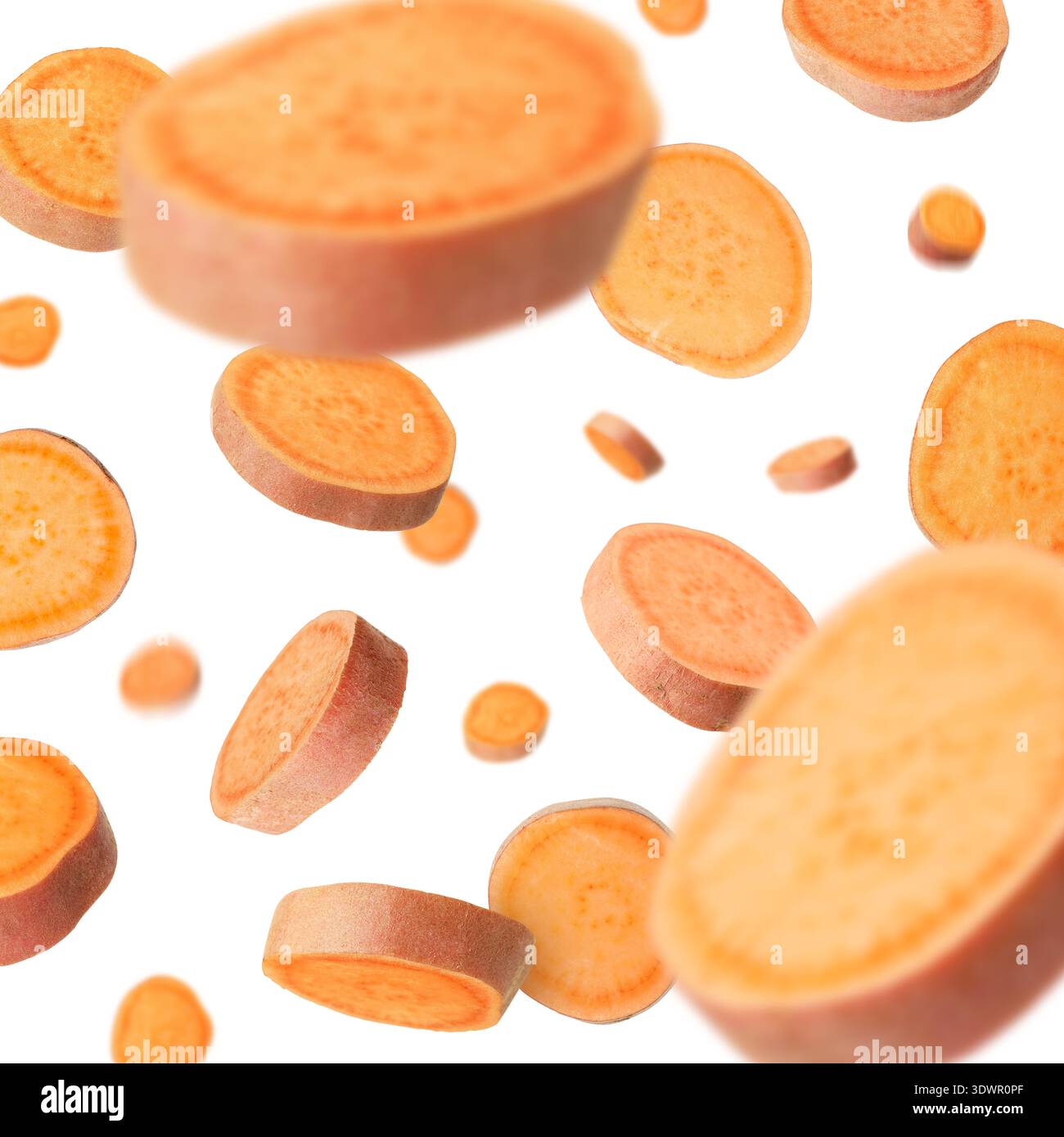 Sweet potato pieces falling against white background Stock Photo