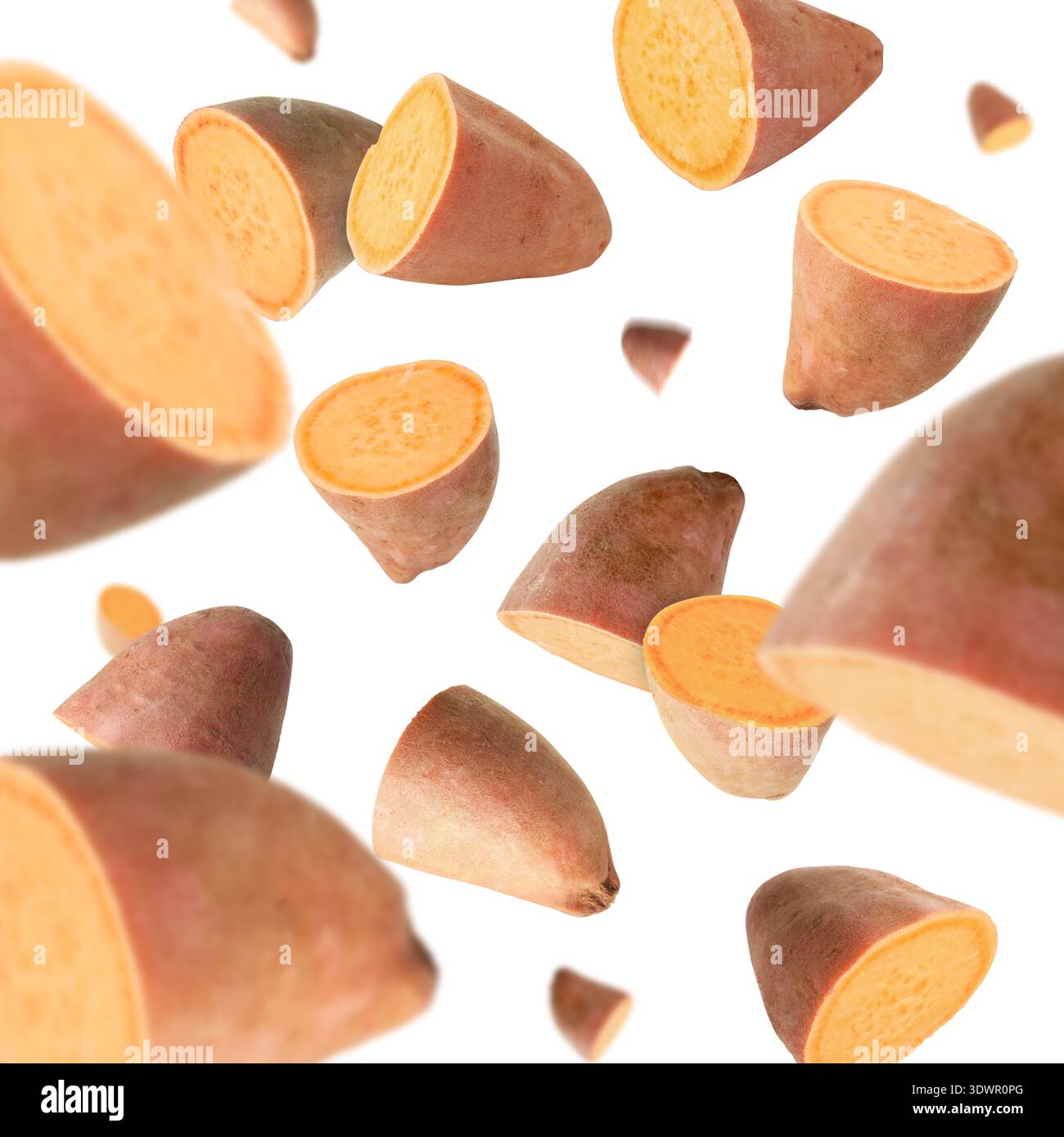 Sweet potato pieces falling against white background Stock Photo