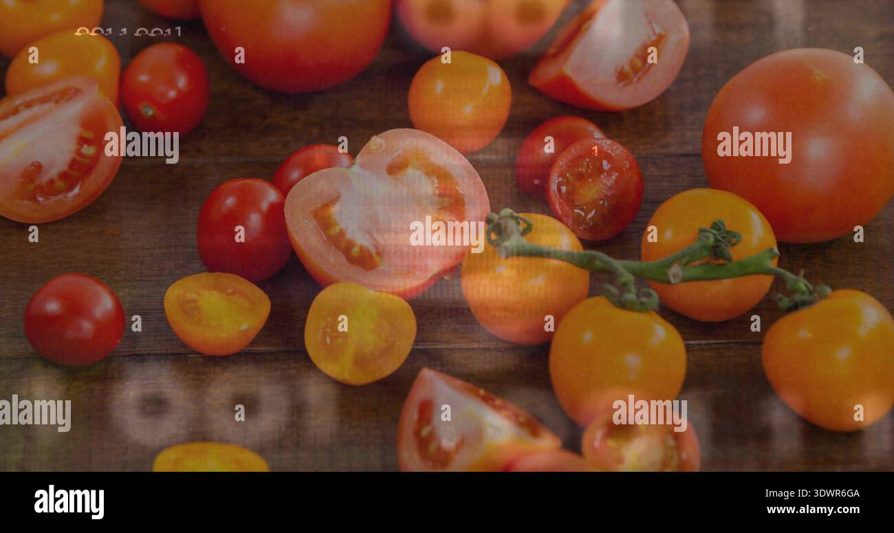 Showing red and yellow tomatoes halved and whole, resting on rustic wood table, vine, timestamp Stock Photo