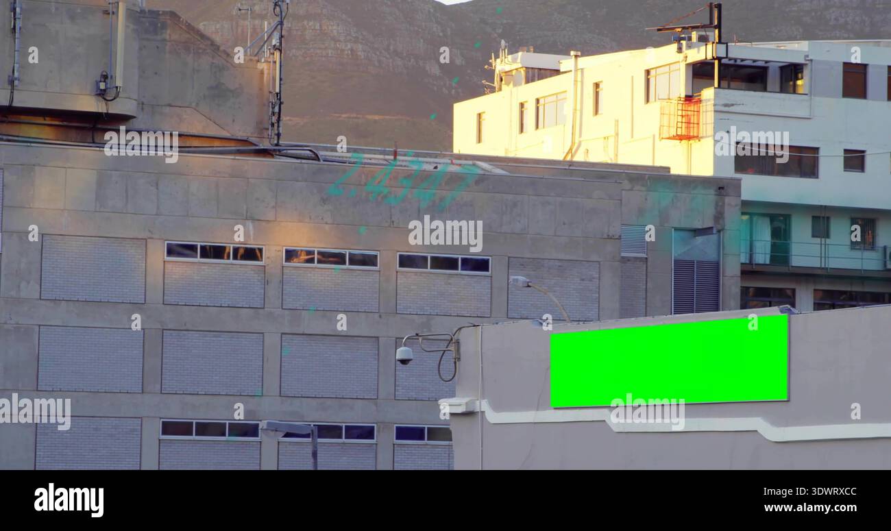 Filling gray concrete building showing slit windows at foothills, green ...