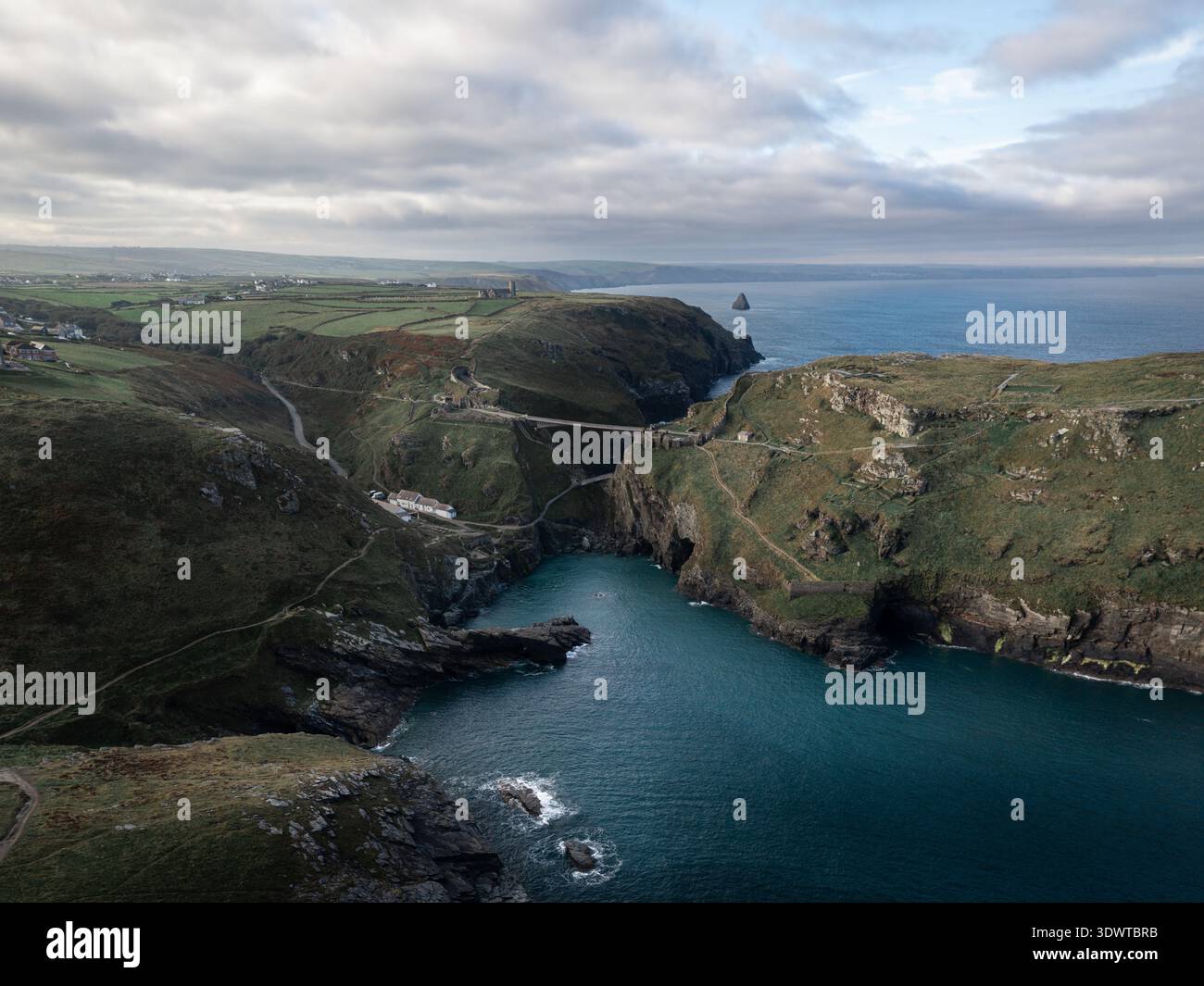 Slender Bridge Aerial view of Tintagel Castle's rugged cliffs meet the teal ocean ...