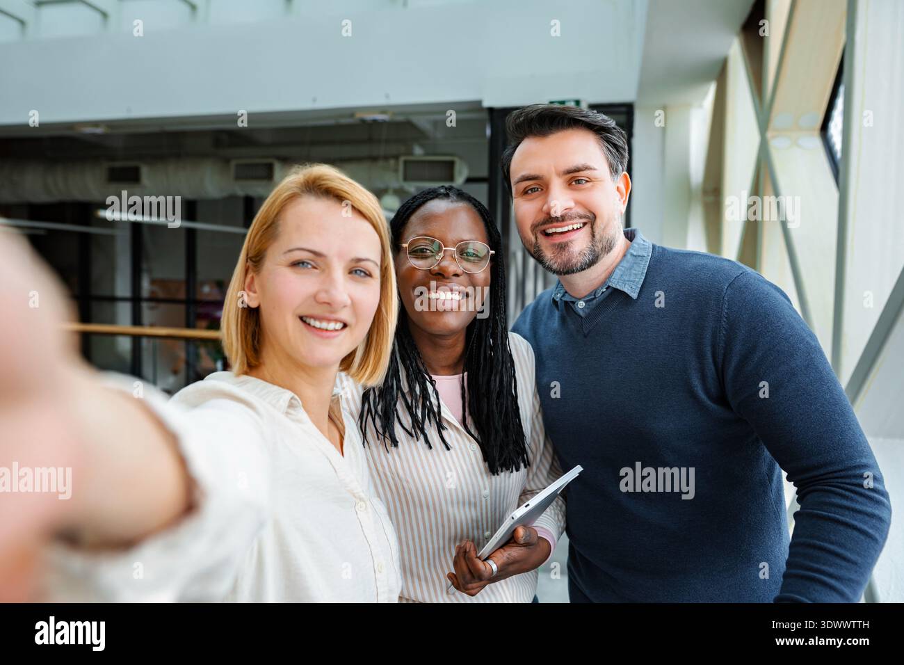 Diverse business team taking selfie in modern office Stock Photo