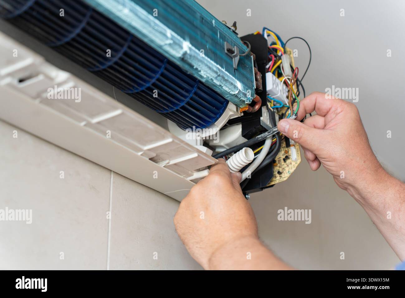 A male air conditioner technician or air conditioning installation. technician is about to repair air conditioning in homes and buildings. Stock Photo