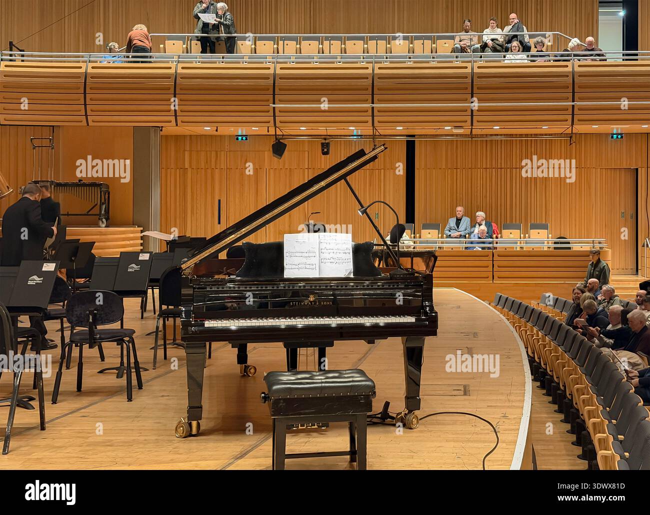 Grand piano positioned center stage in glasshouse, formerly the Sage concert hall with attendees seated on the floor and balcony areas - Smartphone Captured Stock Image