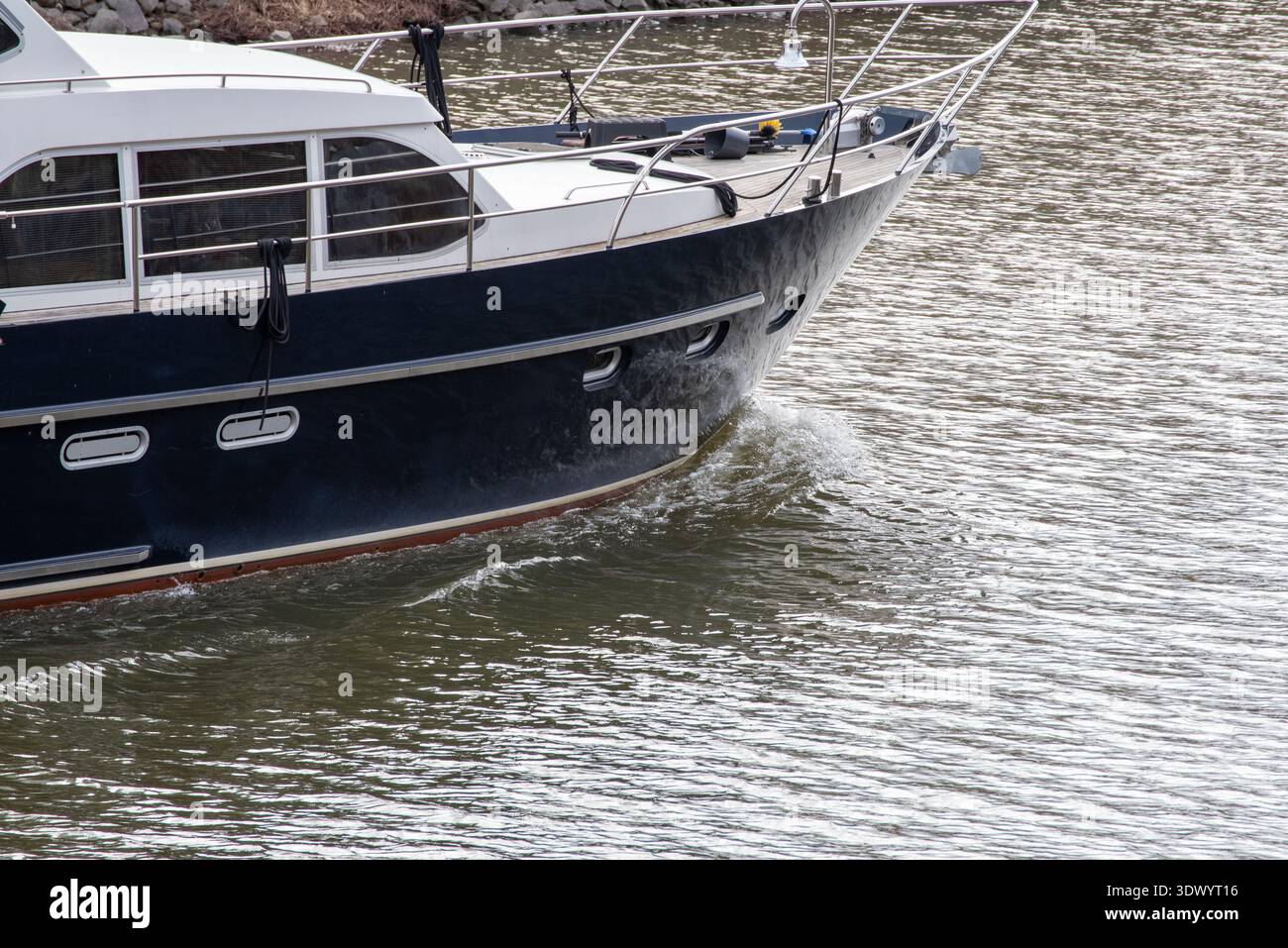 Large Blue Ship Cutting Through Water with Reflected Waves Stock Photo