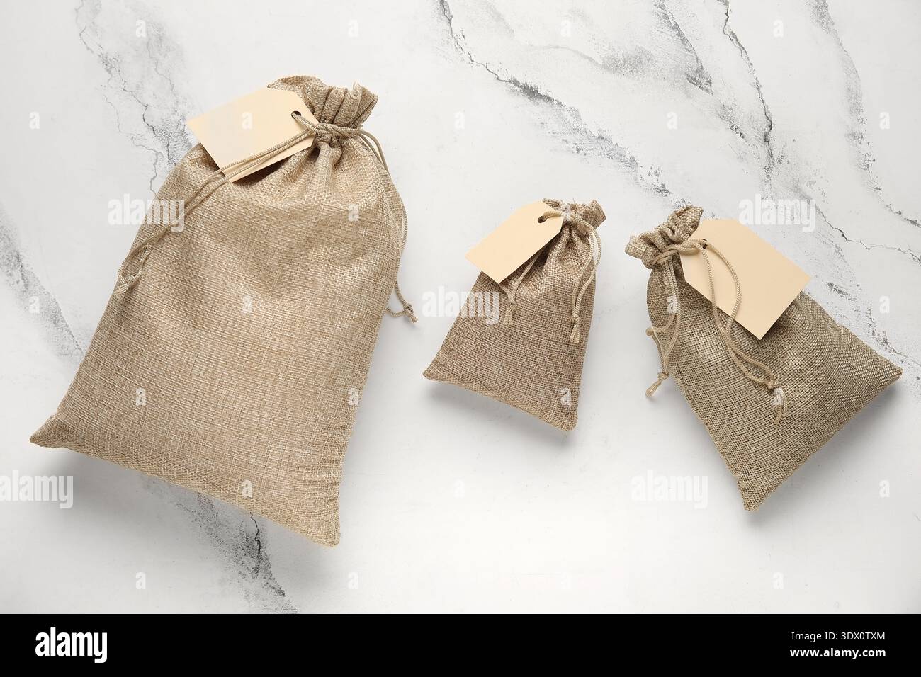 Full sacks with tags on grunge white background Stock Photo