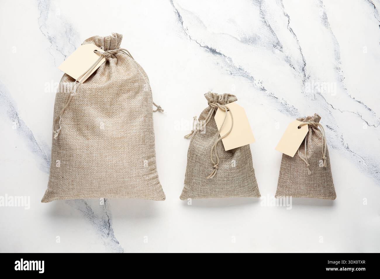 Full sacks with tags on grunge white background Stock Photo