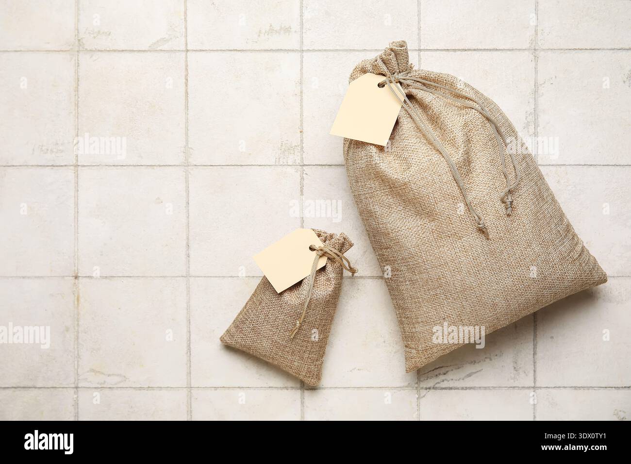 Full sacks with tags on white tile background Stock Photo