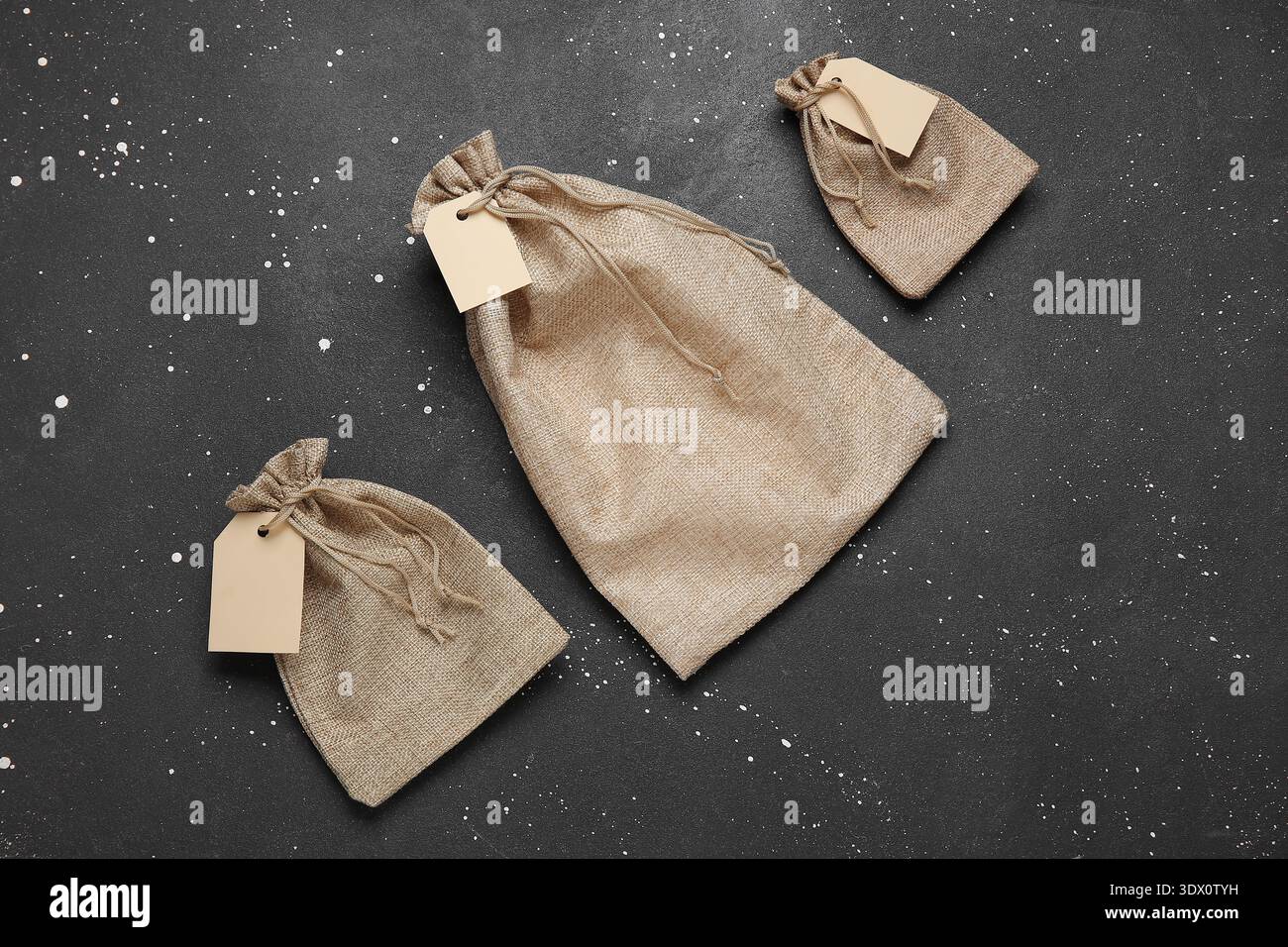 Empty sacks with tags on grunge black background Stock Photo
