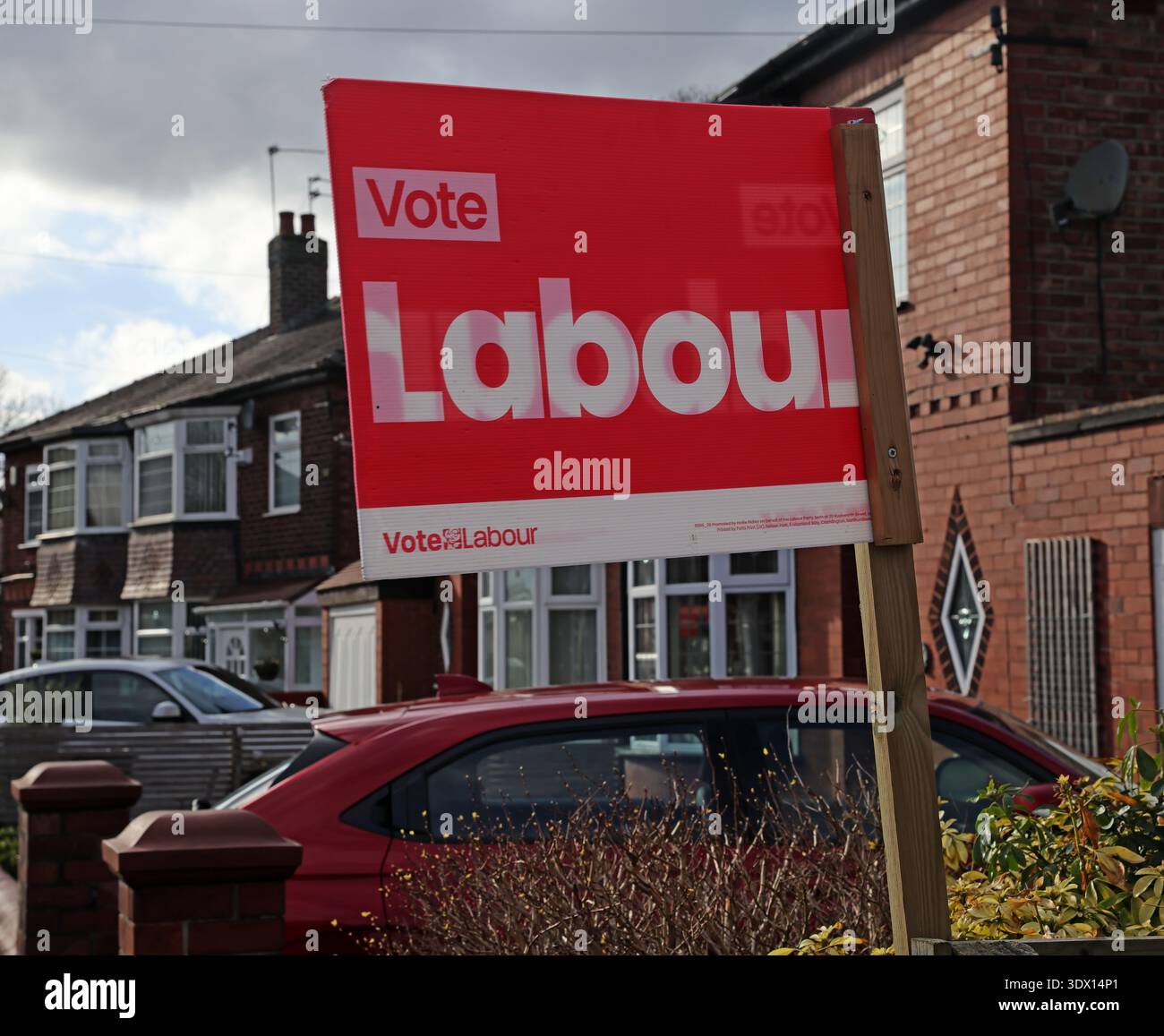 Vote Labour garden placard on a wooden stake outside a suburban home in Gorton, Manchester, Greater Manchester, England, UK. Stock Photo