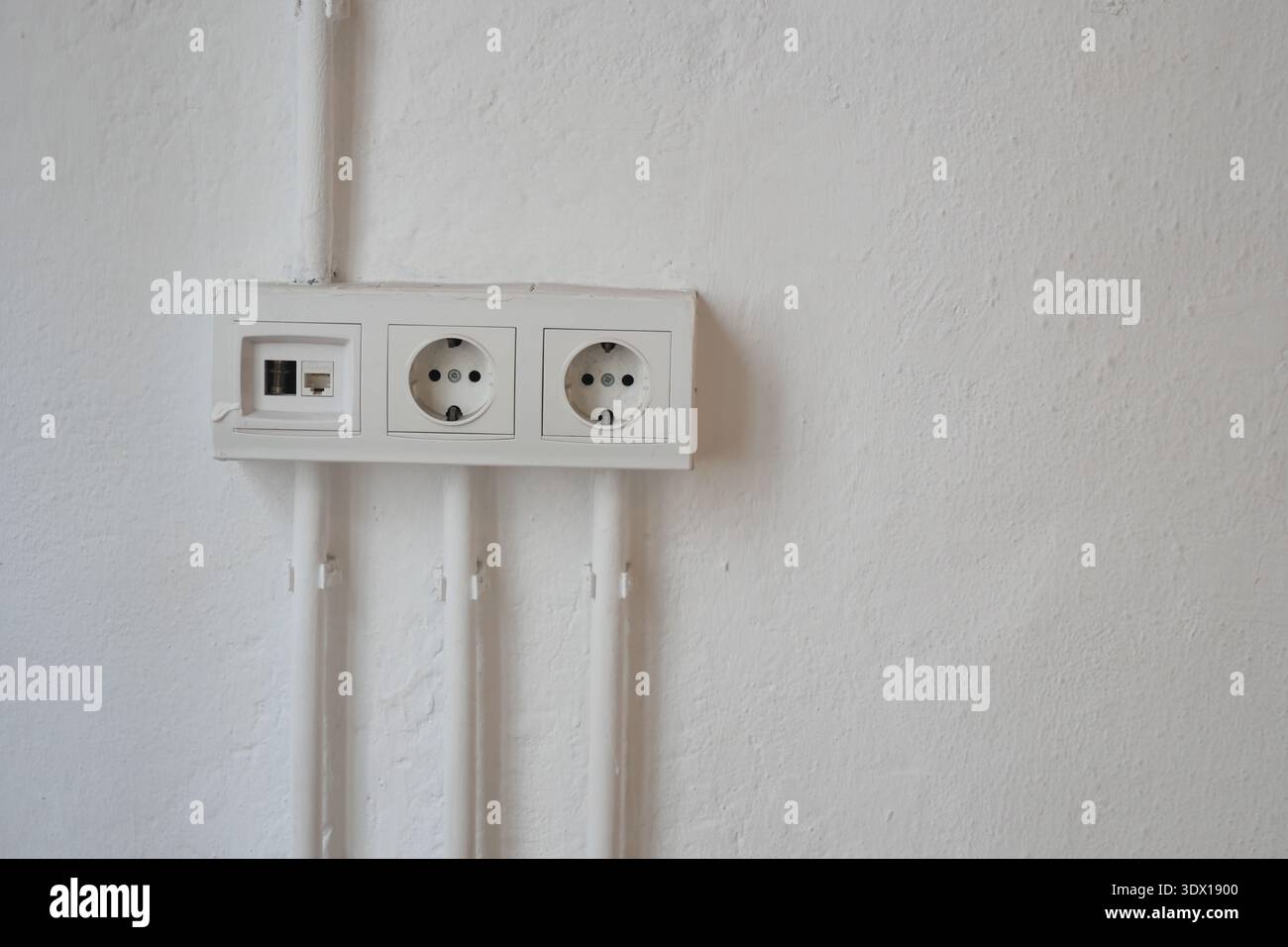 Electrical outlets are installed on a plain wall Stock Photo