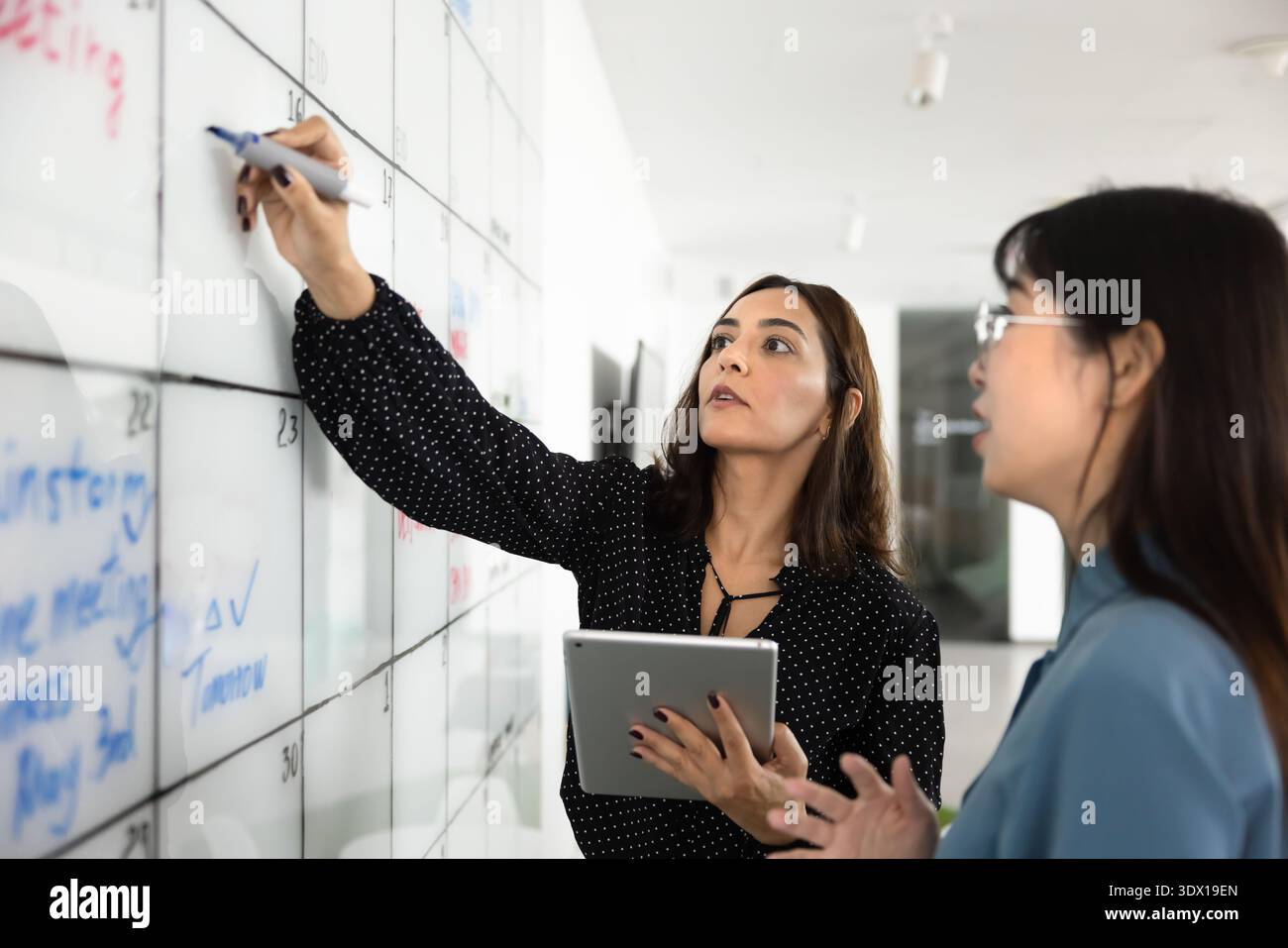 Multiethnic managers using Kanban board for teamwork Stock Photo