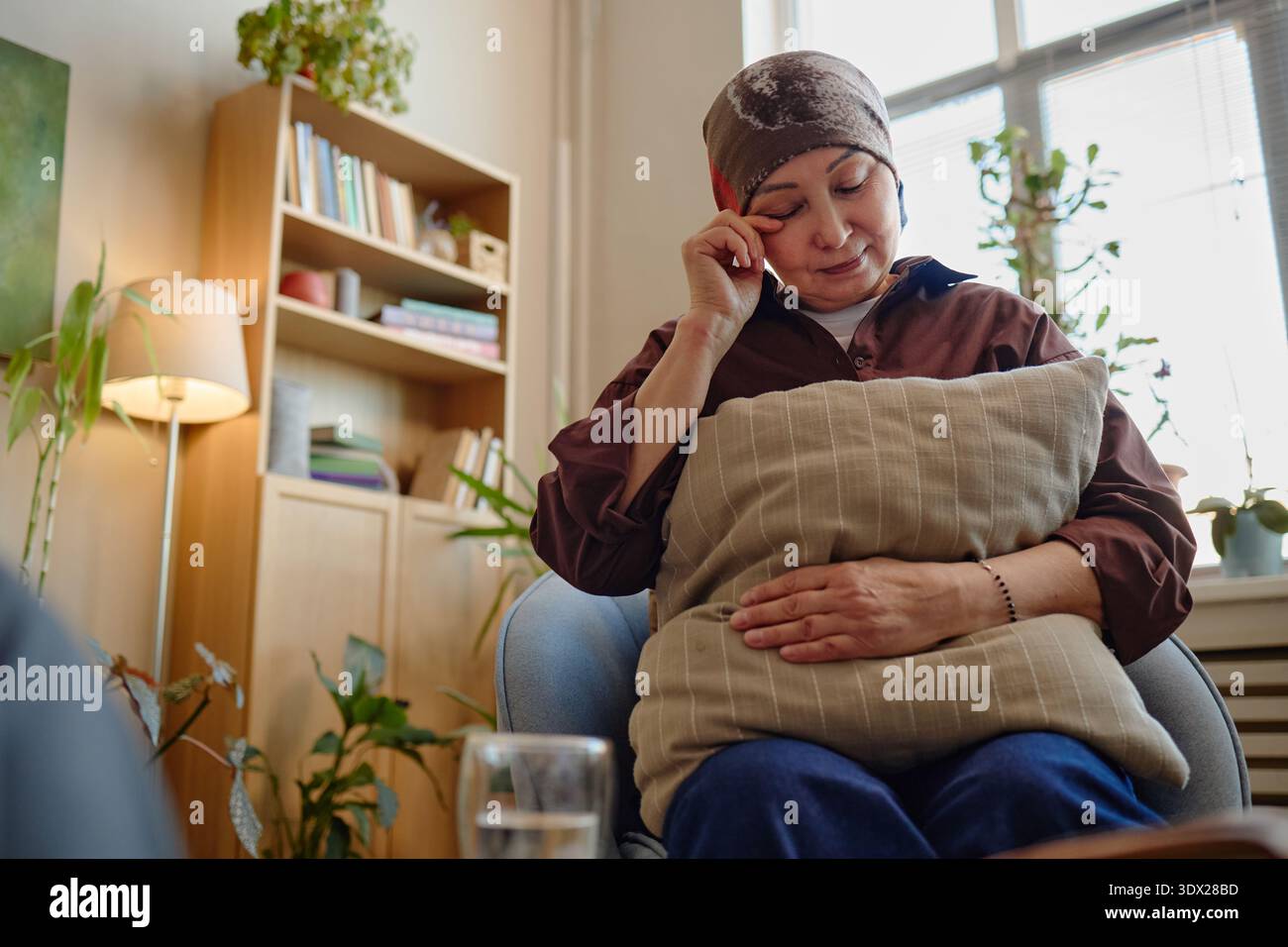 Middle Aged Woman Sitting Alone Reflecting on Emotional Wellbeing Stock Photo