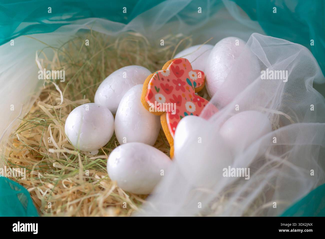 White Easter eggs with decorated bunny cookie in straw nest Stock Photo