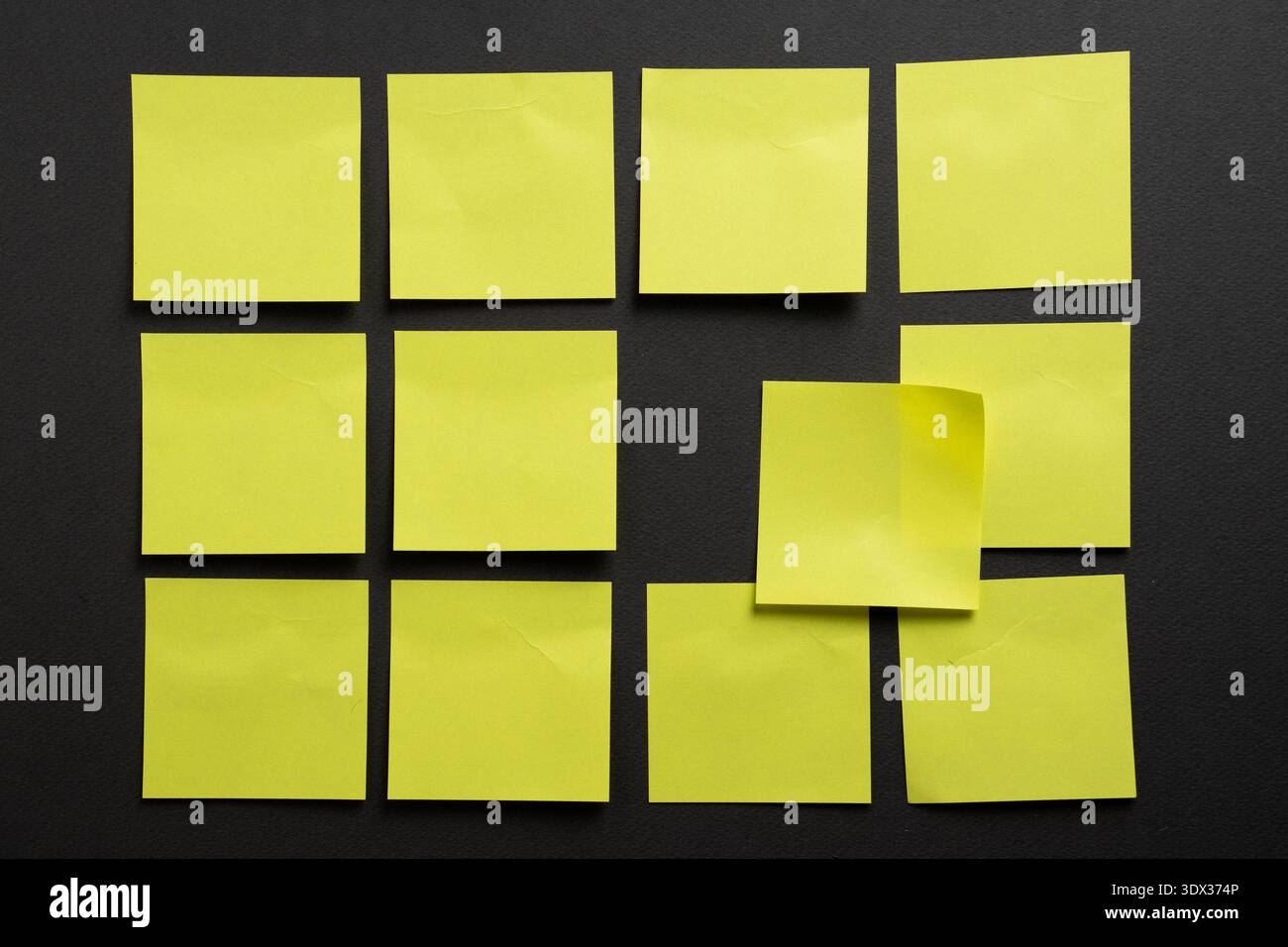 Irregular arrangement of blank yellow sticky notes breaking a grid ...