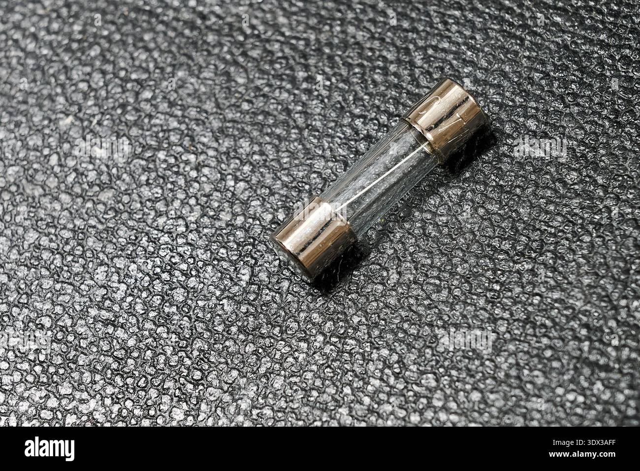 A small transparent fuse on a leather background Stock Photo