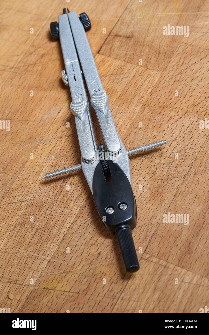 A compass for drawing precise circles on a wooden background Stock Photo