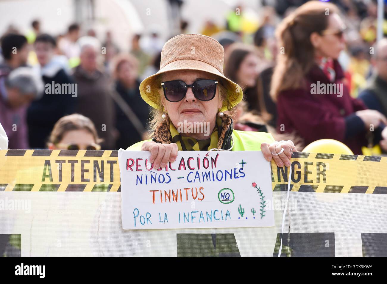 Person carrying a banner with the slogan 'Relocation. Children, trucks ...