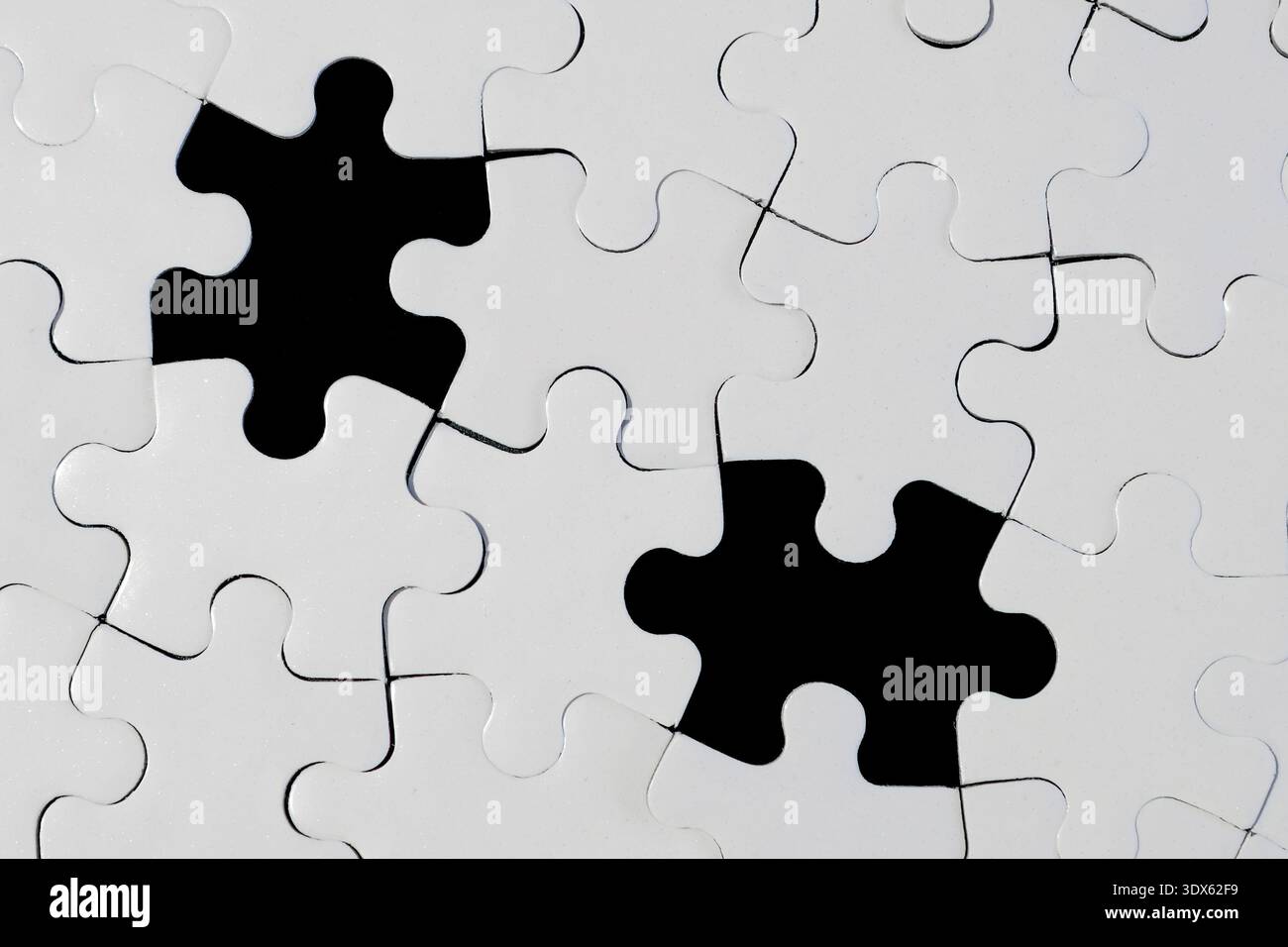 White Jigsaw Puzzle with Two Missing Pieces on Black Background Stock Photo