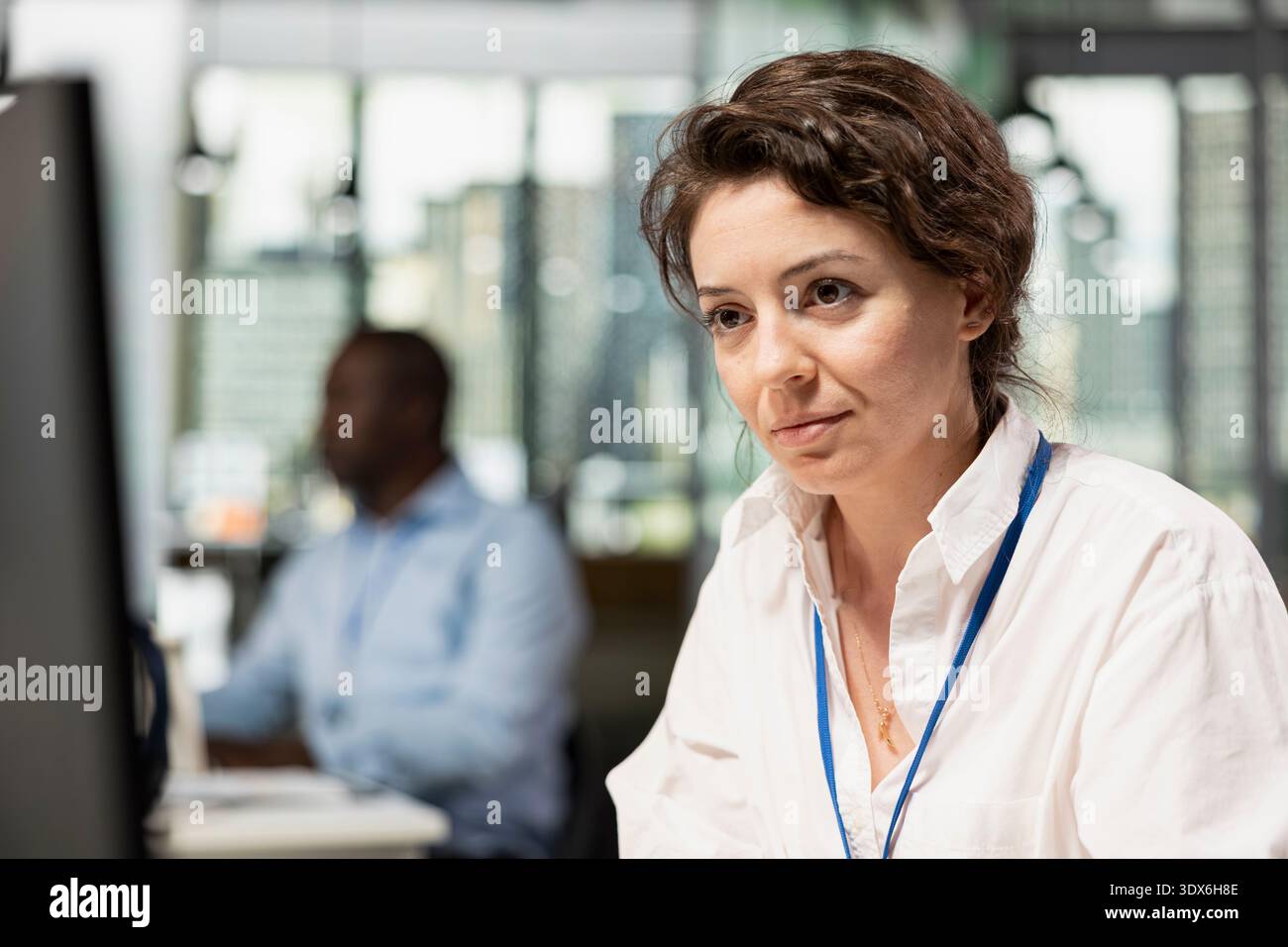 Smiling programmer in Silicon Valley company office developing software apps. Cheerful woman using computer at work to do coding, debugging applications to resolve issues Stock Photo
