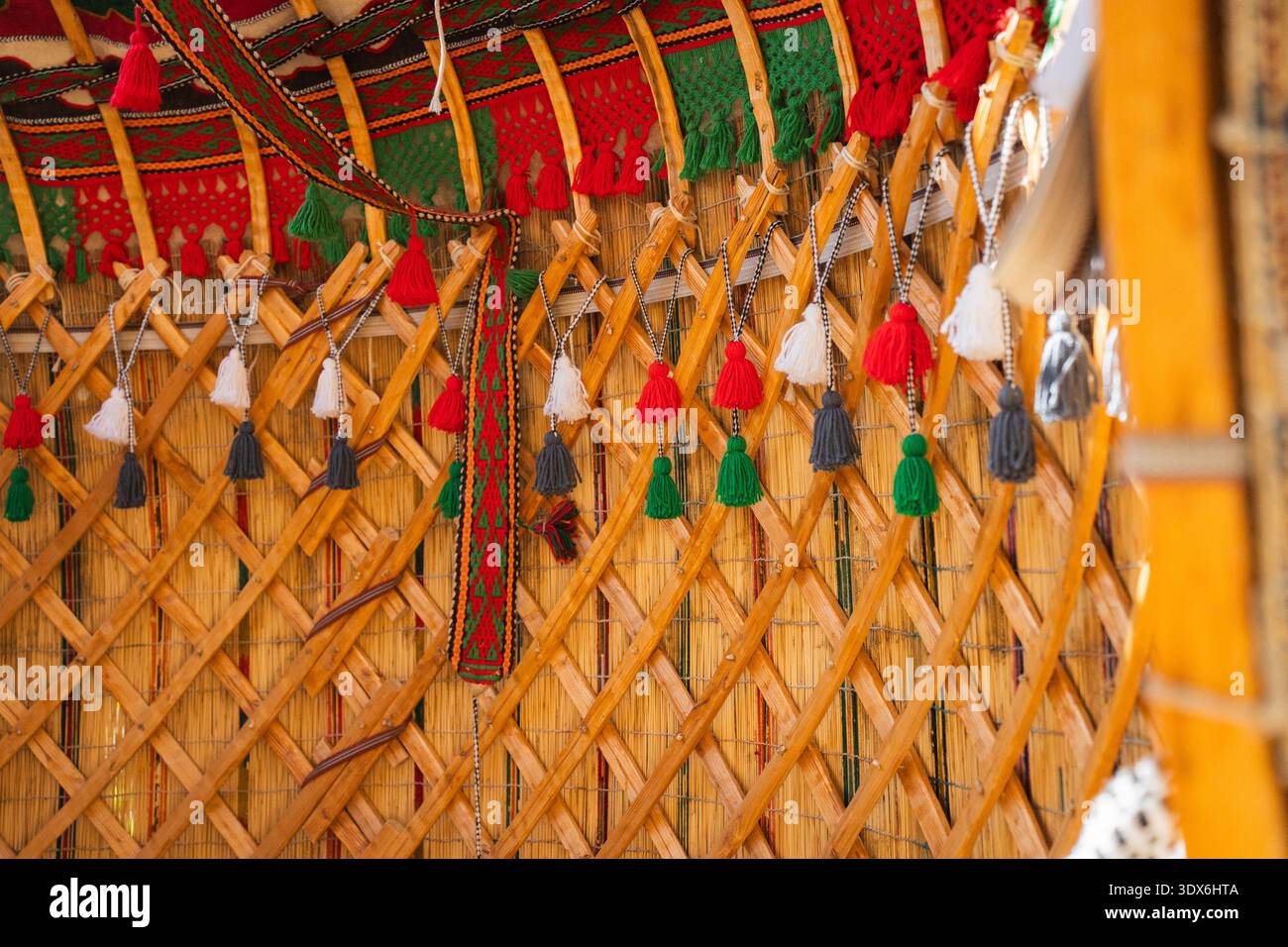 Detailed view of traditional yurt interior with wooden lattice structure and colorful tassel decoration. Authentic Kyrgyz nomadic craftsmanship and te Stock Photo