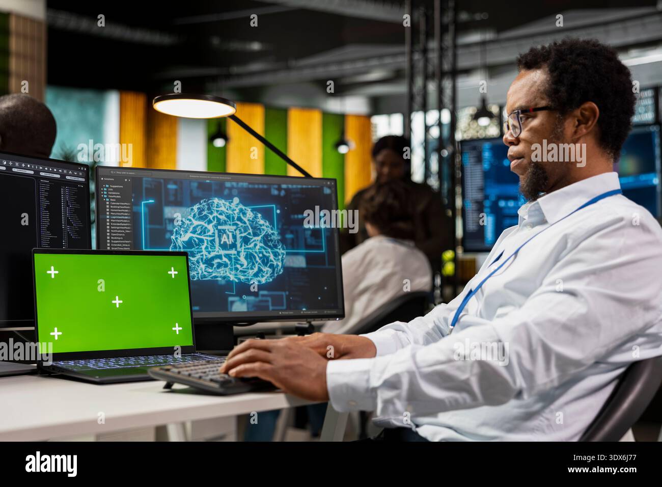 Green screen laptop used by system administrator running AI algorithms in startup workspace. African american man using artificial intelligence deep learning coding platform on mockup notebook Stock Photo