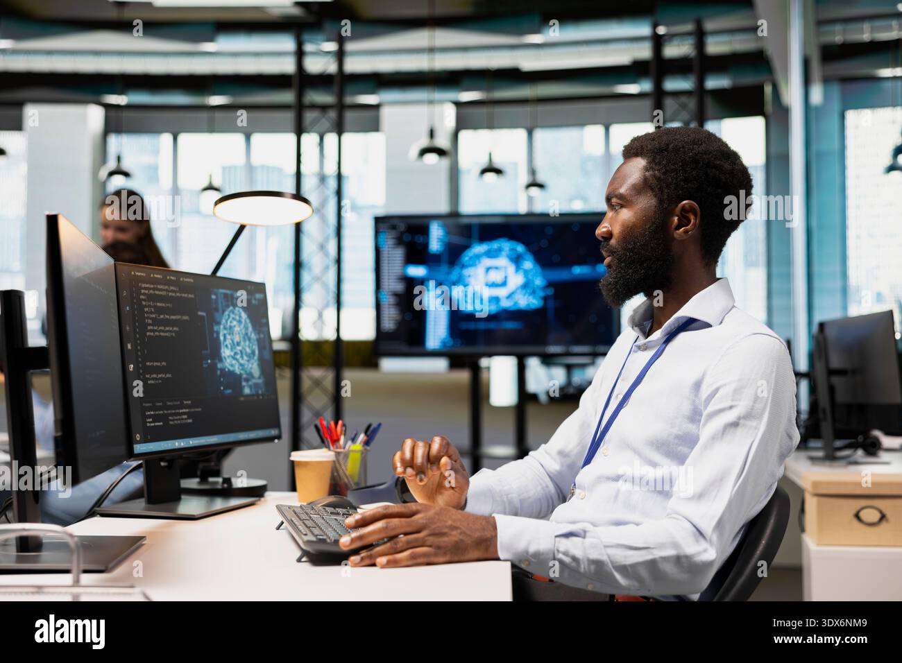 Software developer writing code, developing machine learning APIs. African american man in office working, troubleshooting software errors using artificial intelligence tech Stock Photo