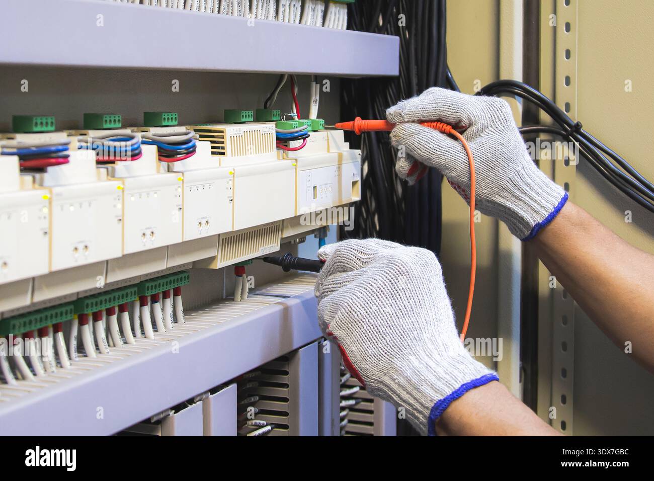 Technicians use multimeter to test or diagnose electrical control devices. Stock Photo