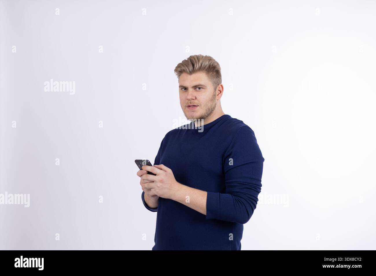 Young man using smartphone with a serious look Stock Photo