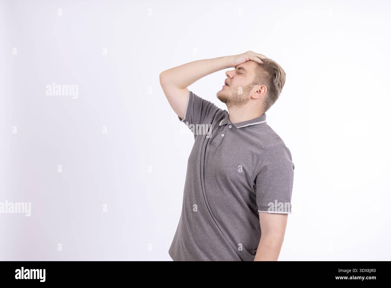 Young man touching his head in frustration Stock Photo