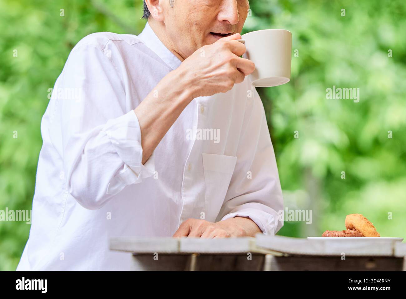Senior man drinking coffee on terrace Stock Photo