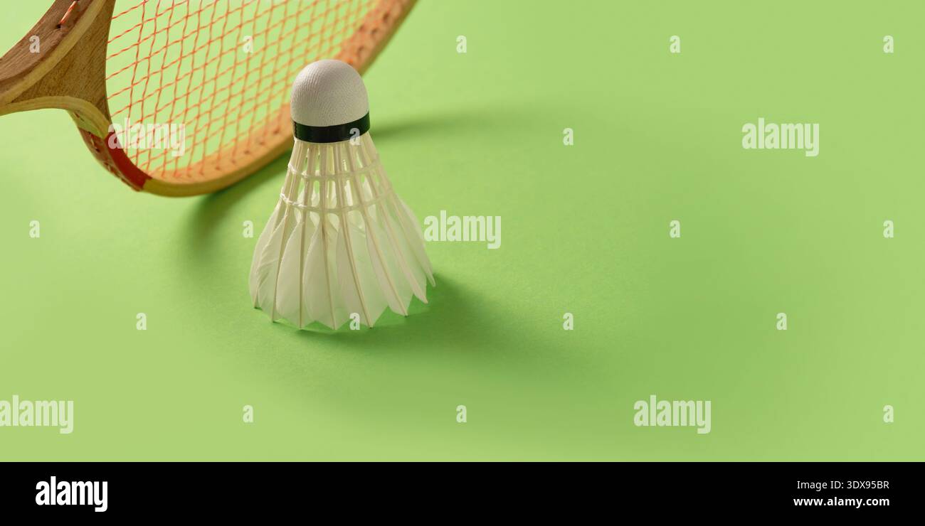 White badminton shuttlecock standing on bright green background with ...